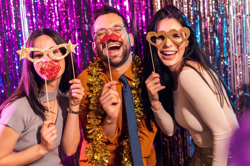 Guests posing with glitter props at a night event