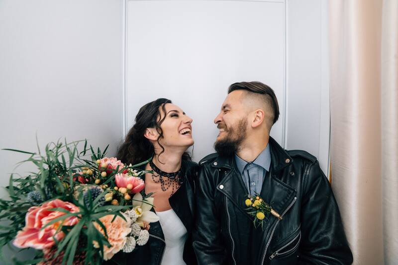 Bride and groom laughing together during a photo booth session